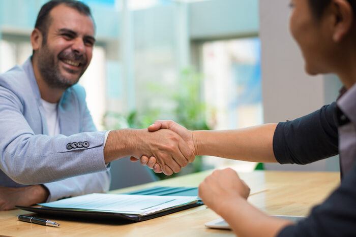 Photo of man and woman shaking hands illustrates blog: "Networking: How to Get Started"
