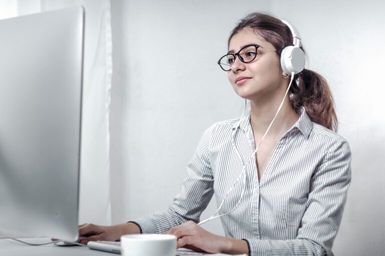 Photo of woman in front of computer illustrates blog: "How to Improve Your Hiring Process in 2022"