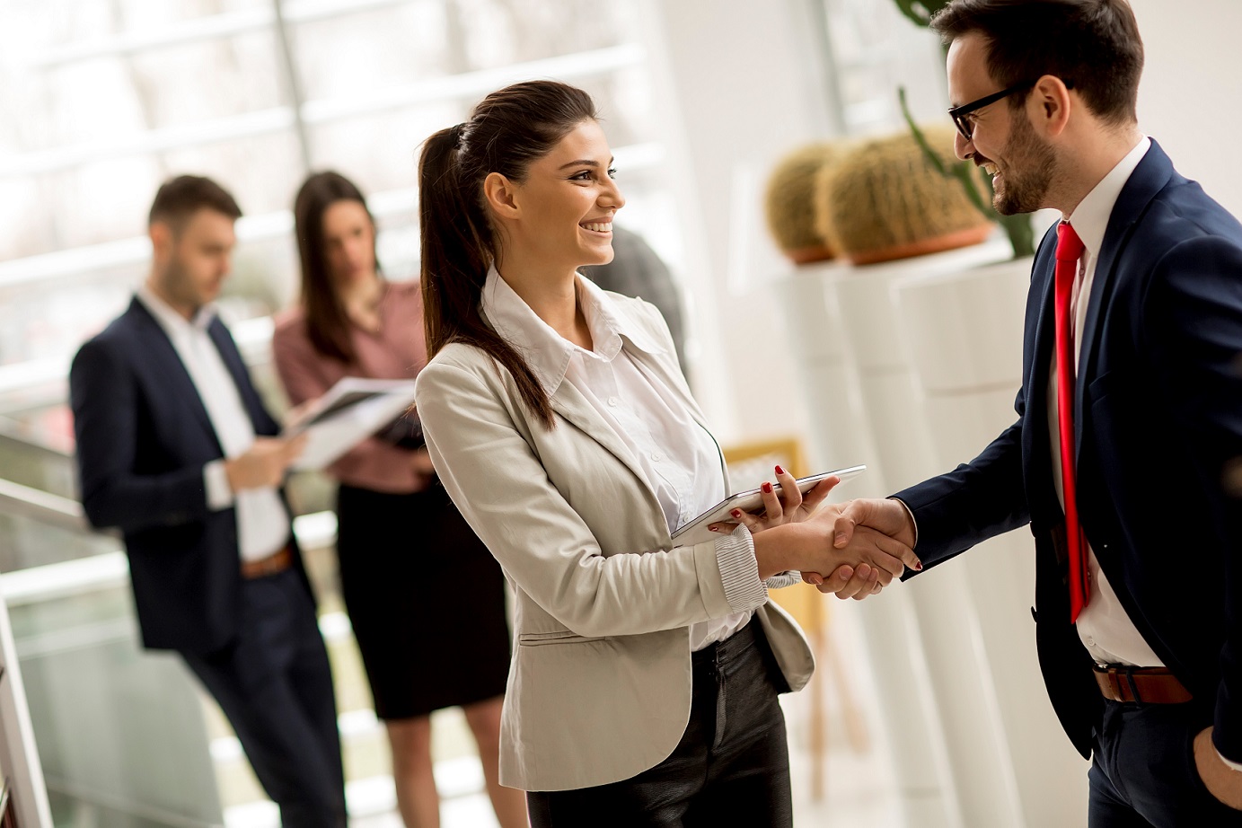 Photo of businesswoman and businessman shaking hands illustrates blog: "9 Entrepreneurship Quotes to Give You the Motivation and Wisdom You Need"