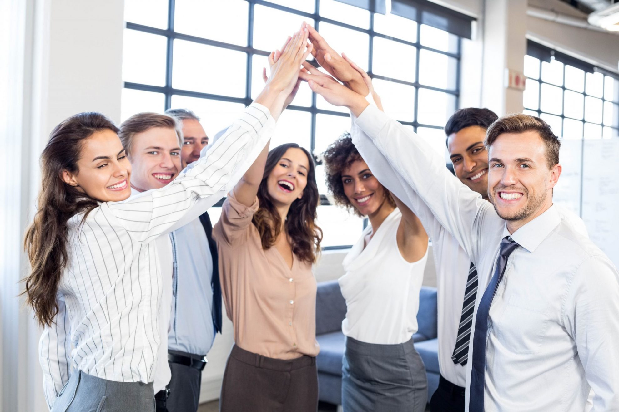 Group of smiling employees illustrate blog: "Keeping Employees Happy and Productive: How to Reduce Employee Turnover"