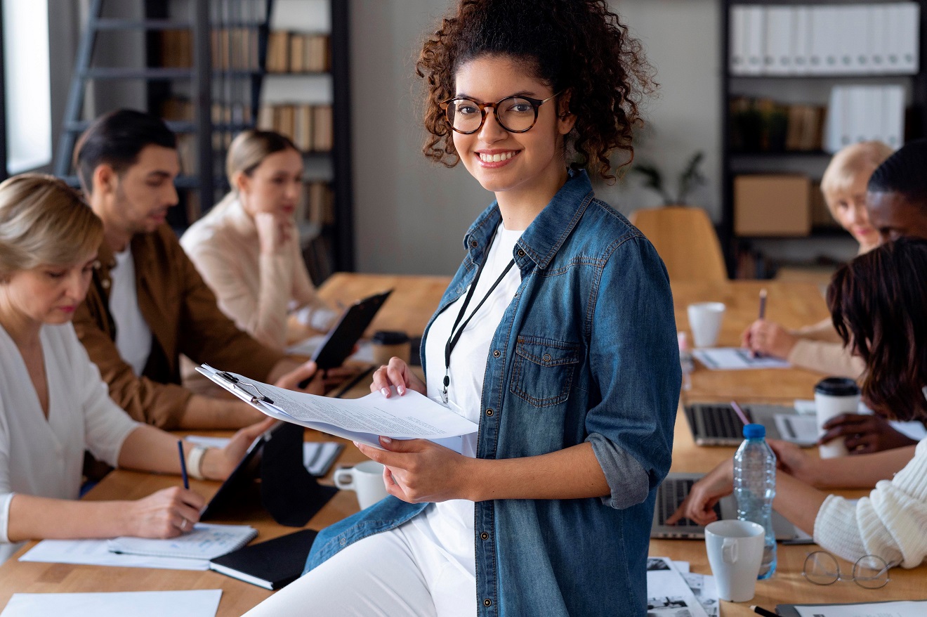 business-woman-FP Smiling woman in meeting room illustrates blog "5 Tips To Be More Organized"