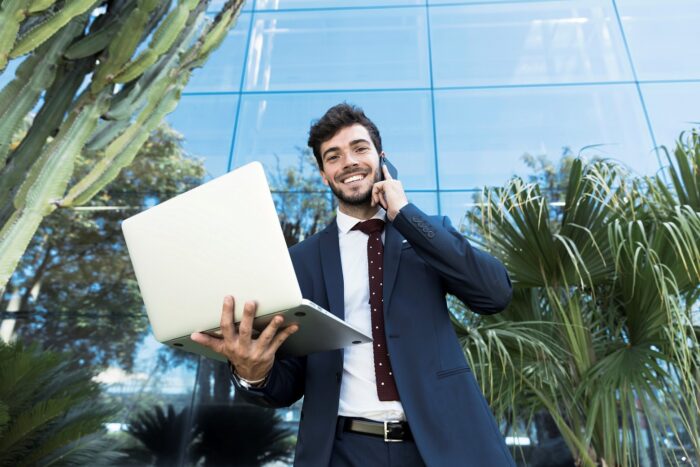 Young man in business suit holding laptop illustrates blog "5 Tips for New Entrepreneurs"