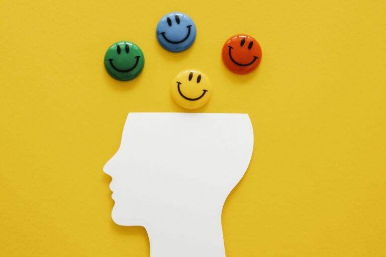 Profile of person with smiley faces placed above the head illustrates blog "The Importance of Emotional Intelligence for Entrepreneurs"