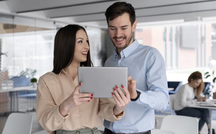 Woman and man looking at laptop illustrate blog "What Is the Best Business Structure for a Small Business?"