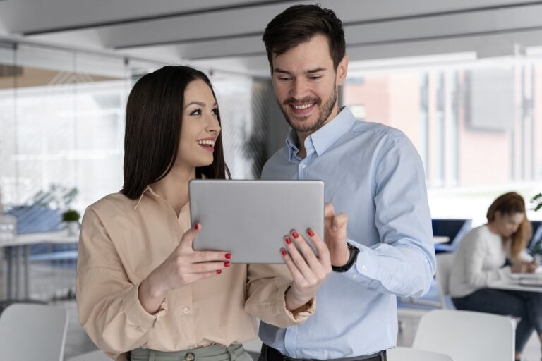 Woman and man looking at laptop illustrate blog "What Is the Best Business Structure for a Small Business?"
