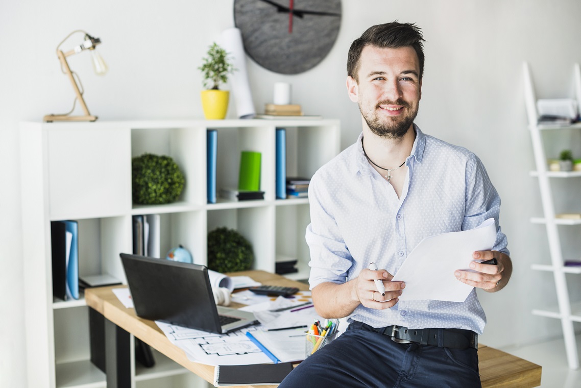 man-office-freepik Man in office with laptop illustrates blog "Protecting Your Business from Cyber Threats: A Practical Guide"